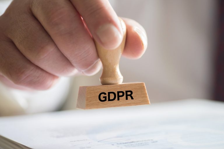 Käsi ojentaa leimasinta missä lukee GDPR