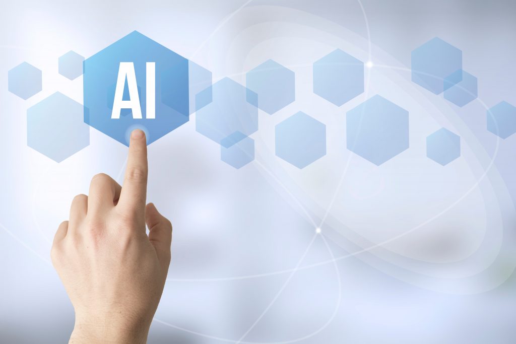 Sormi koskettaa kuusikulmaista symbolia missä lukee AI