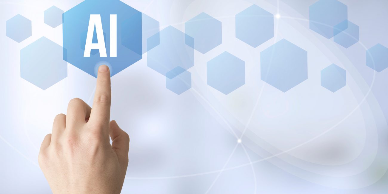 Sormi koskettaa kuusikulmaista symbolia missä lukee AI